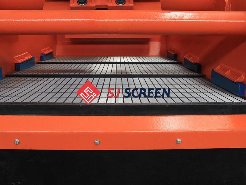 Three pieces of composite frame shale shaker screens installed in an orange shaker.